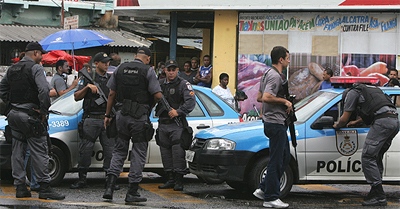 Policiais militares observam viatura onde estavam colegas executados em Madureira