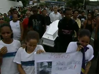 Colegas de turma carregam cartaz em homenagem a Mateus durante o seu enterro